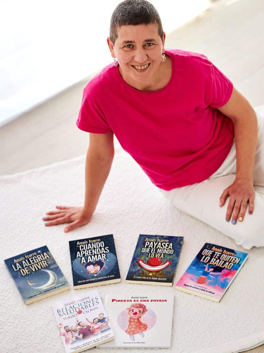 Anaís Isarre sentada en el suelo junto a sus 6 libros de desarrollo personal. Autora de la saga la Alegría de Vivir.